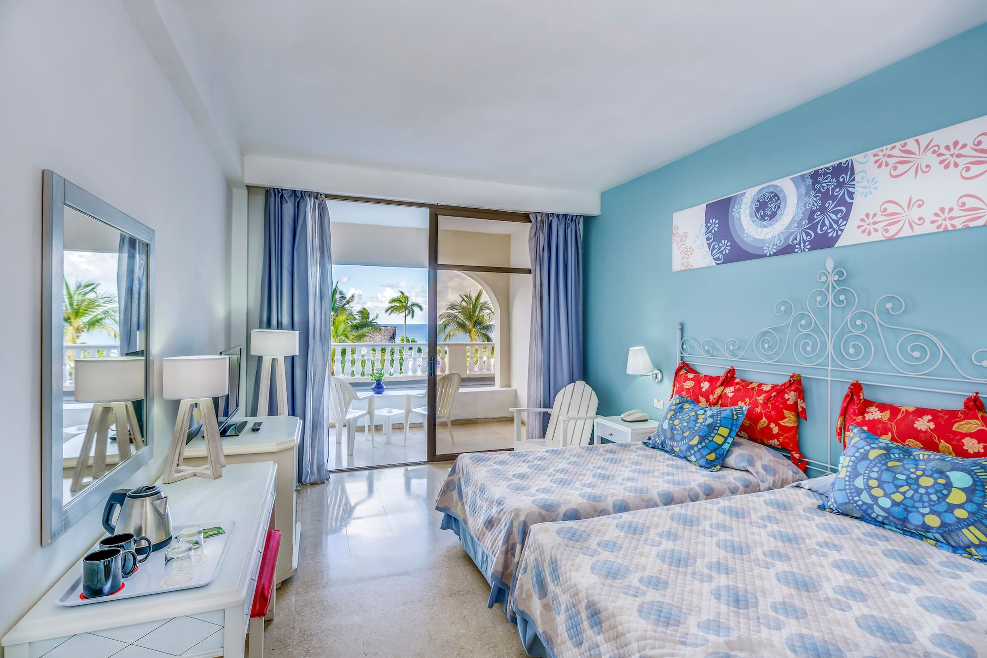 a bedroom with two beds and a glass door