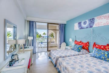 a bedroom with two beds and a glass door