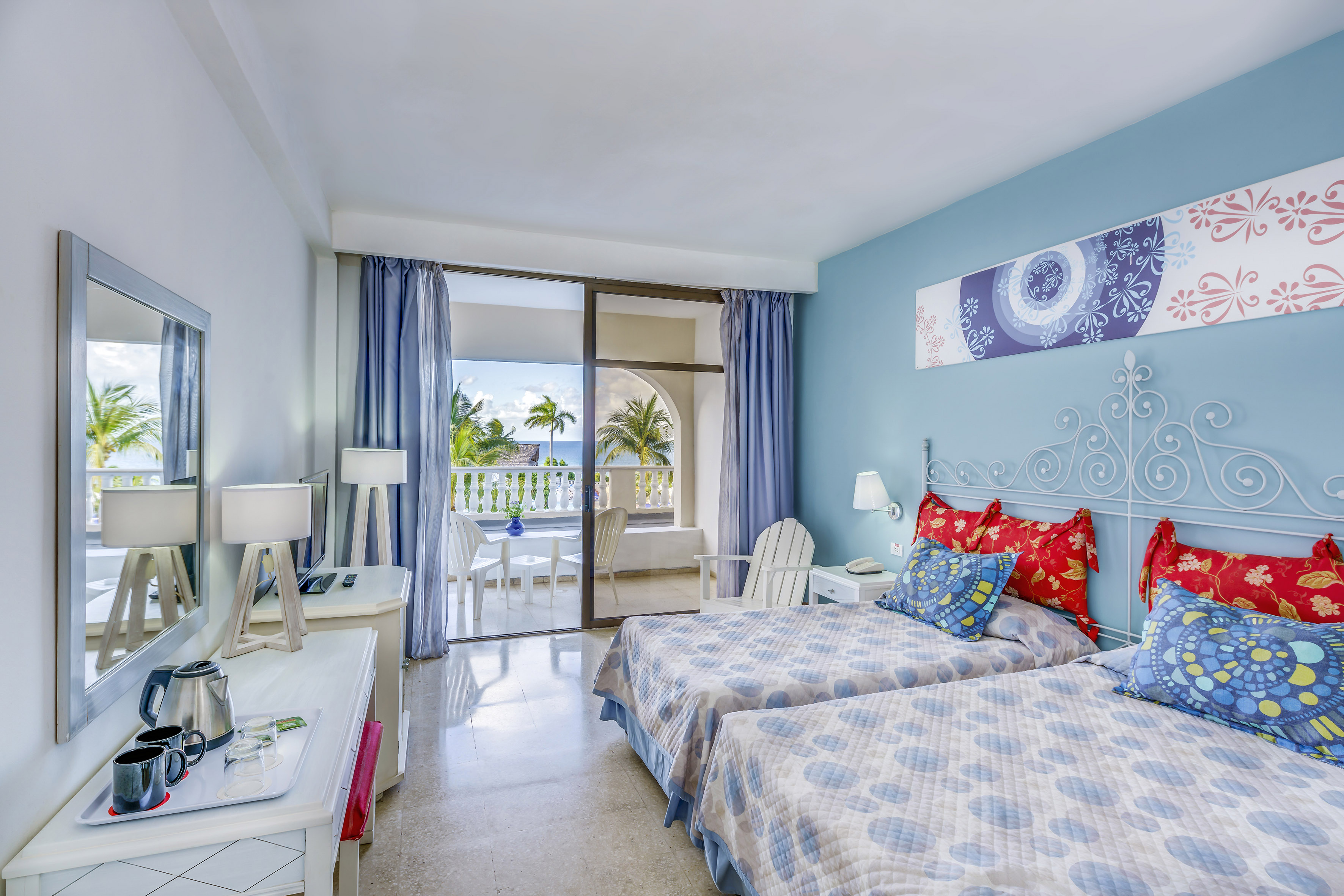 a bedroom with two beds and a glass door