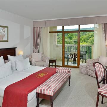 a hotel room with a bed and chairs