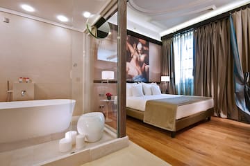 a bedroom with a glass shower and a bed