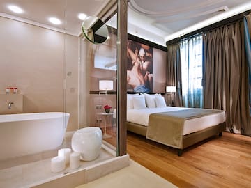 a bedroom with a glass shower and a bed