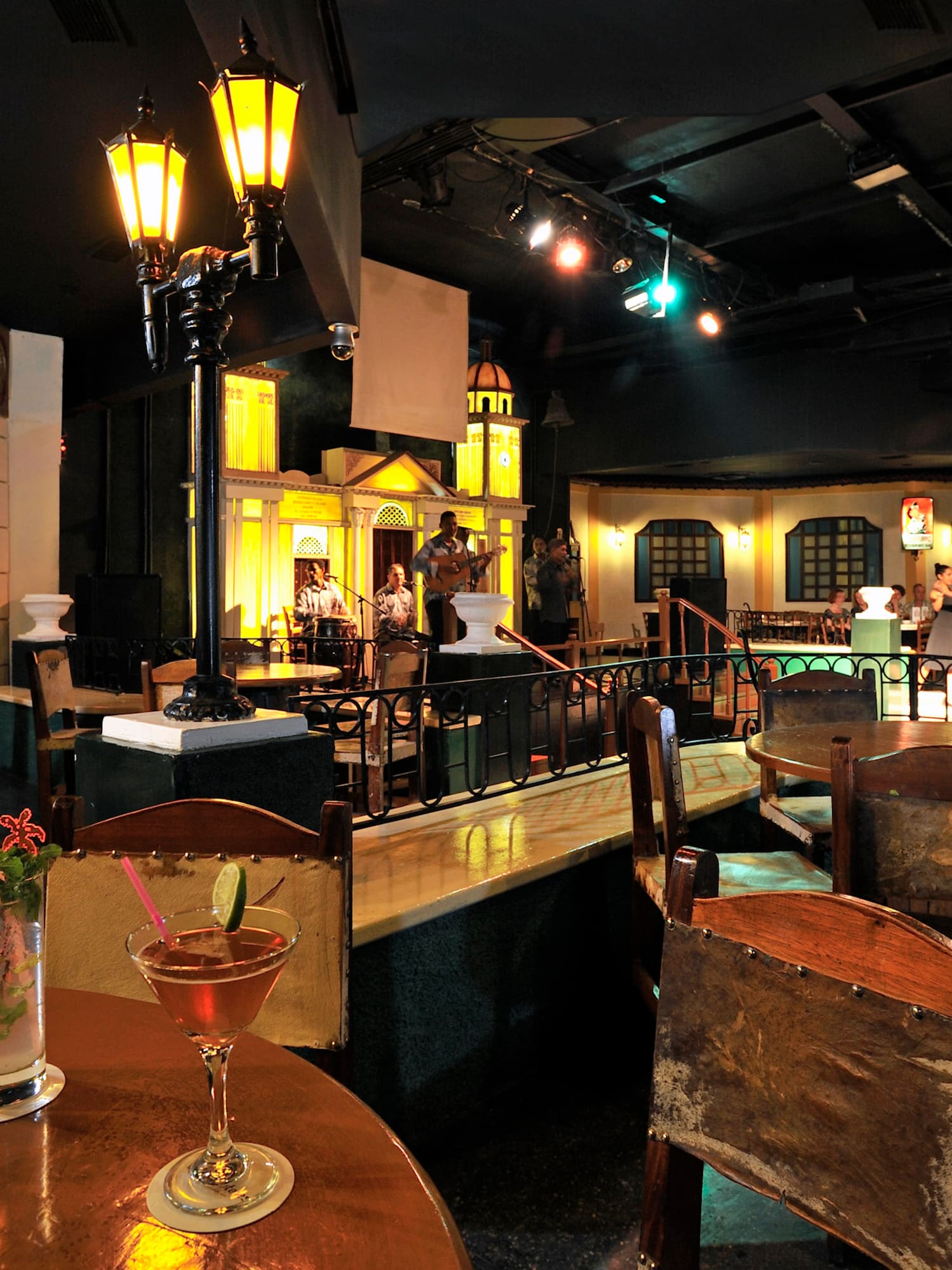 a room with tables and chairs and a group of people