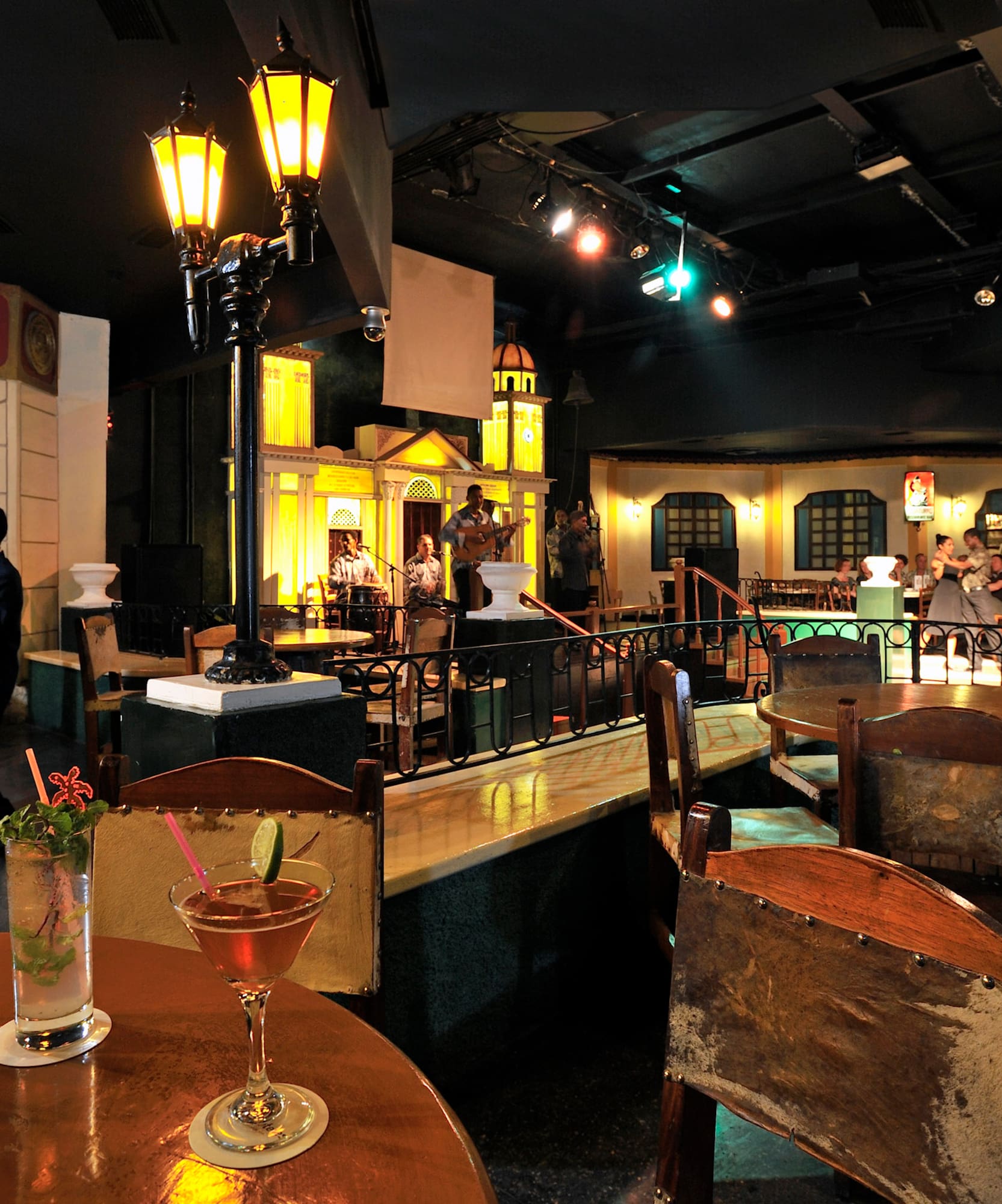 a room with tables and chairs and a group of people