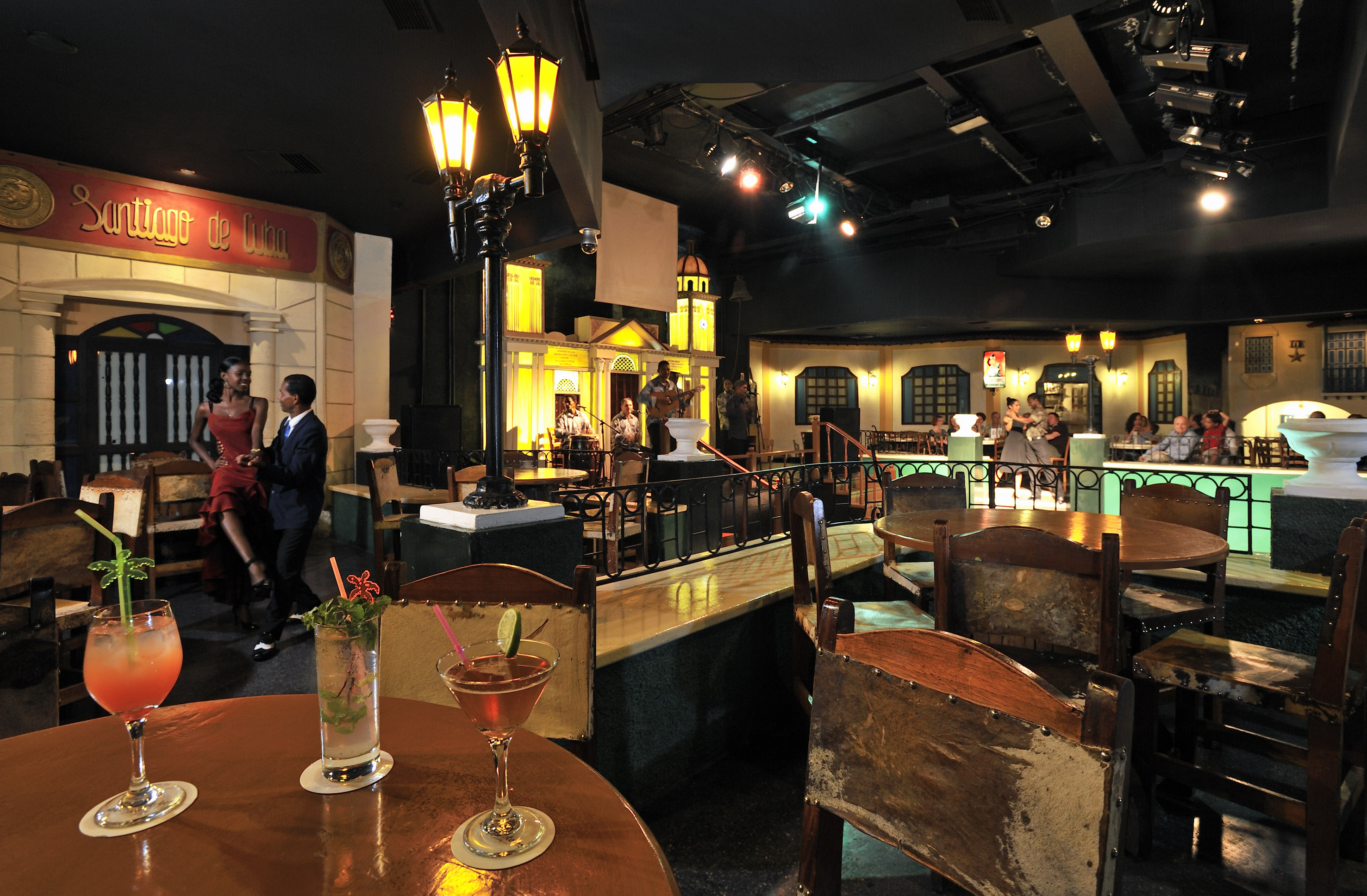 a room with tables and chairs and a group of people