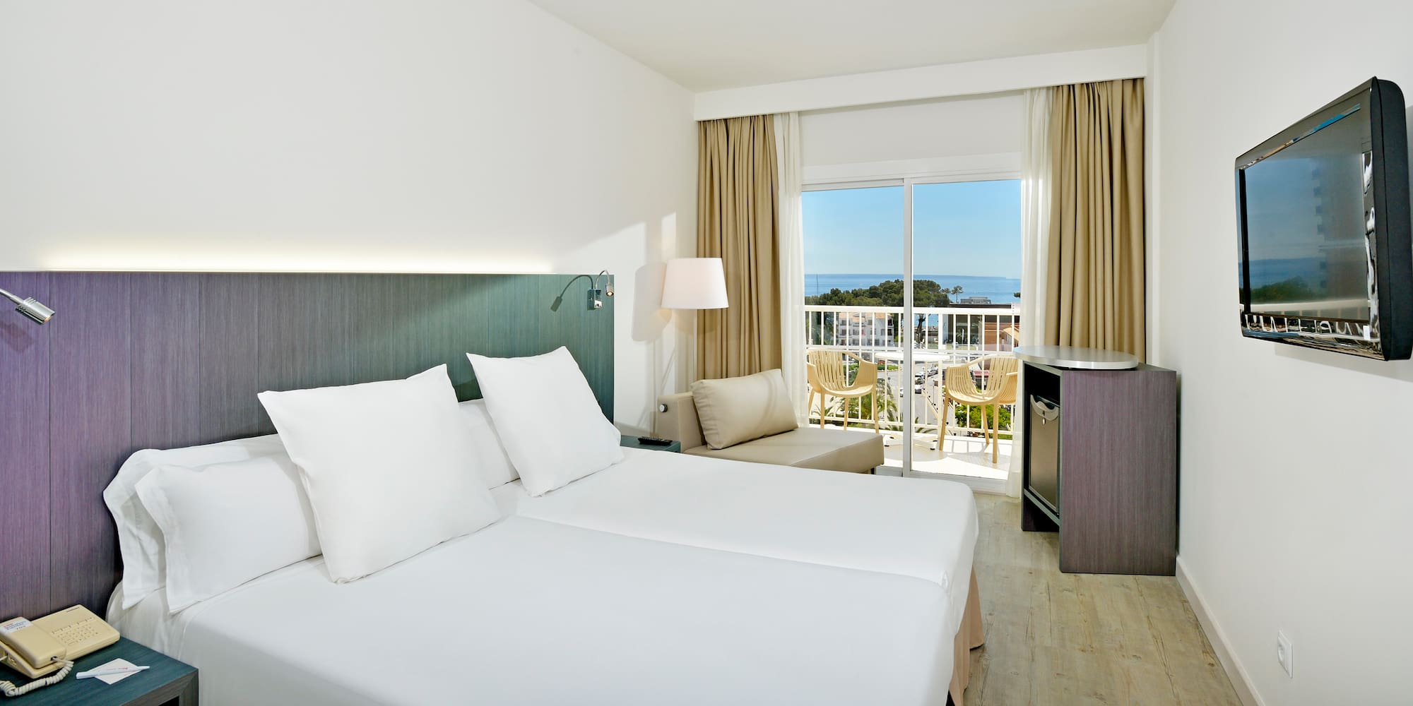 a room with two beds and a balcony