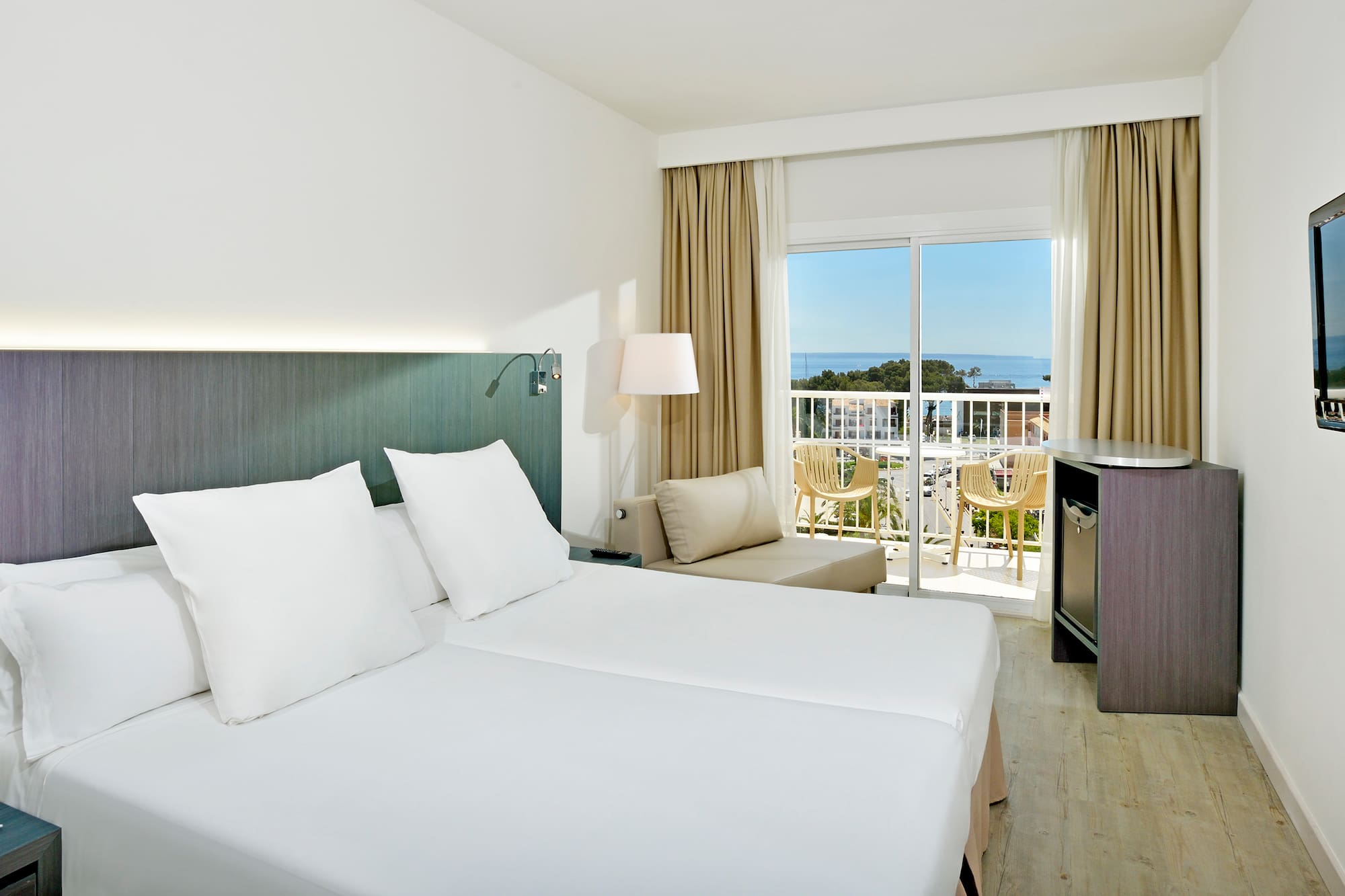 a room with two beds and a balcony