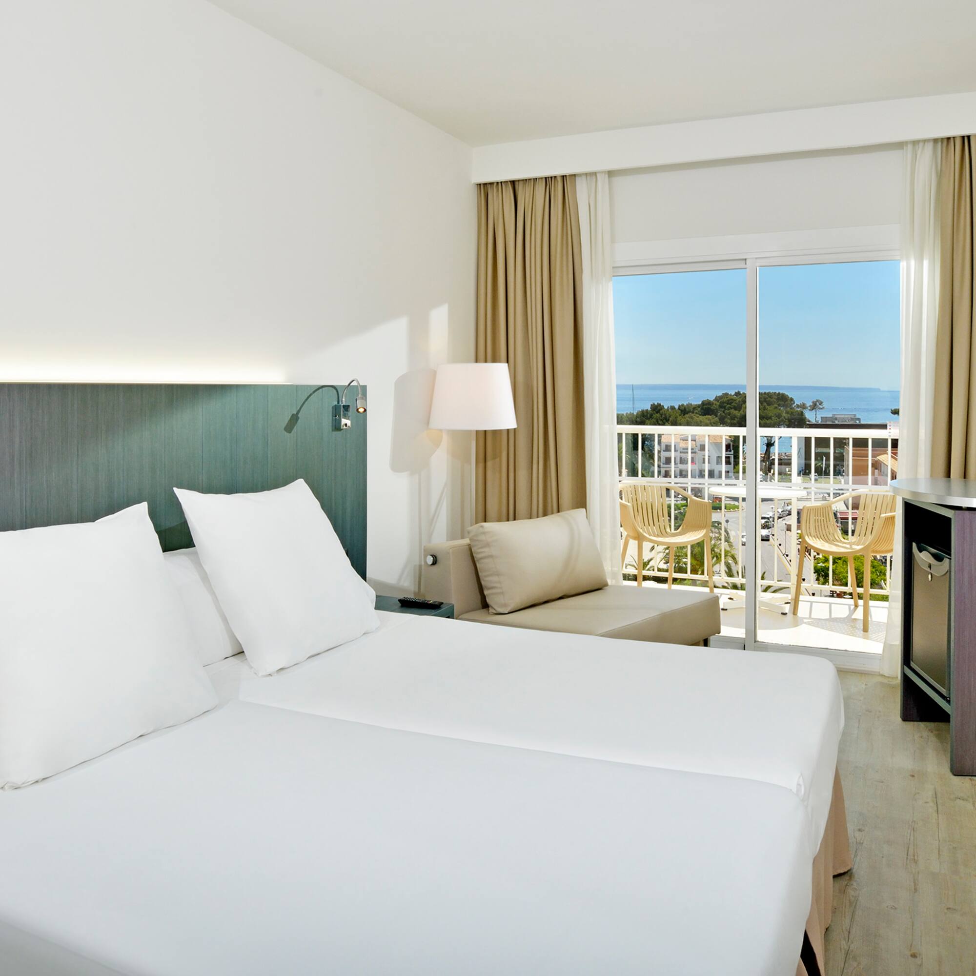 a room with two beds and a balcony