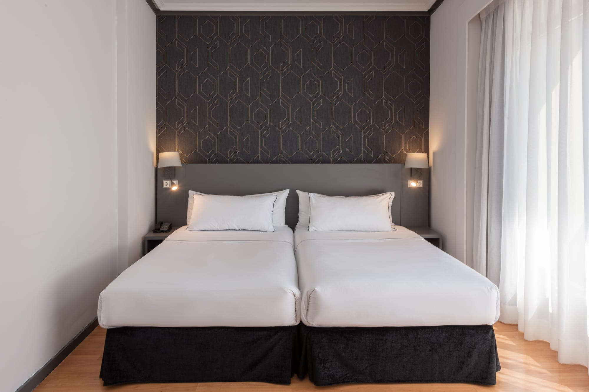 a bed with white sheets and pillows