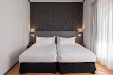 a bed with white sheets and pillows