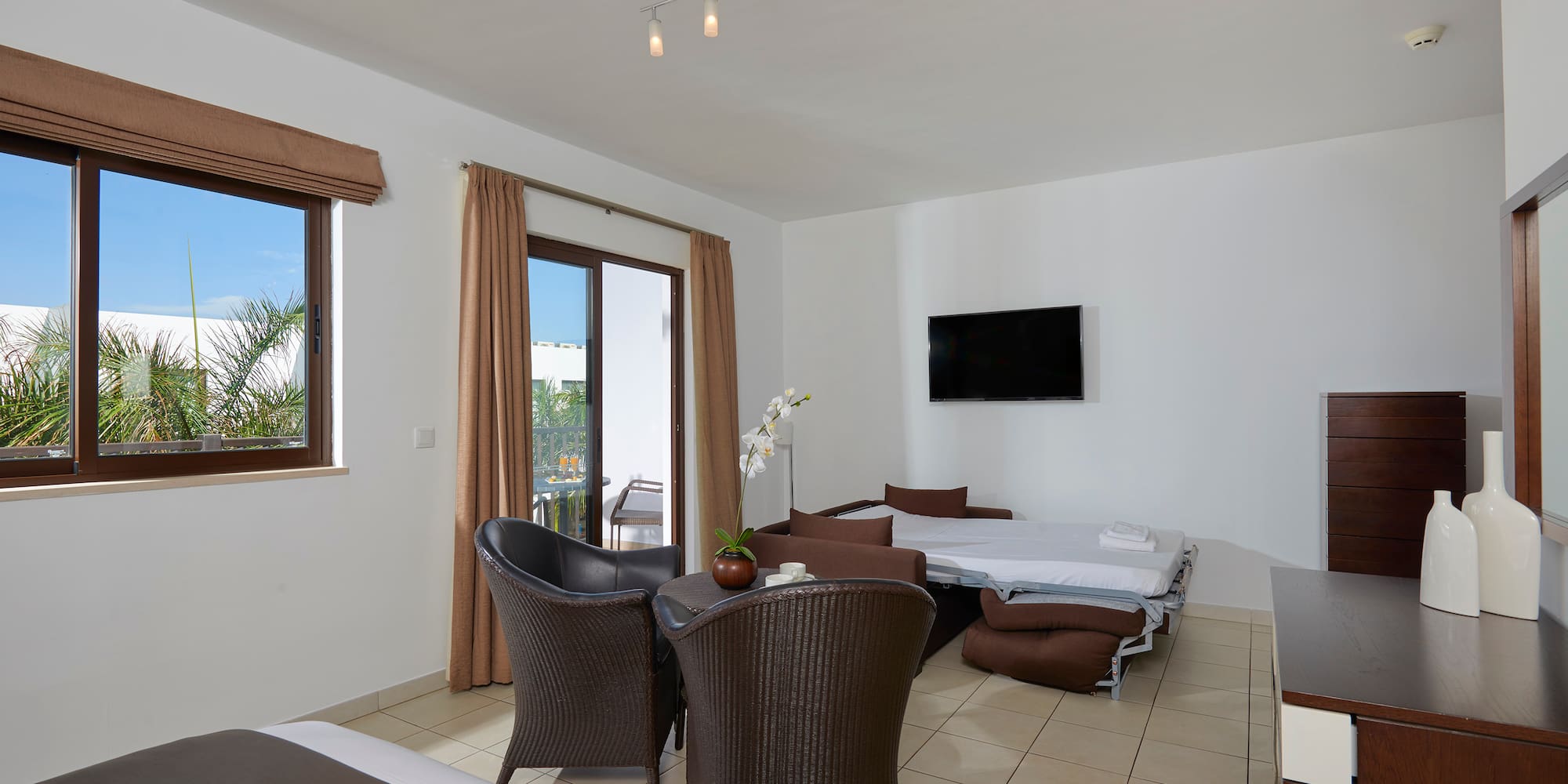 a room with a bed and chairs