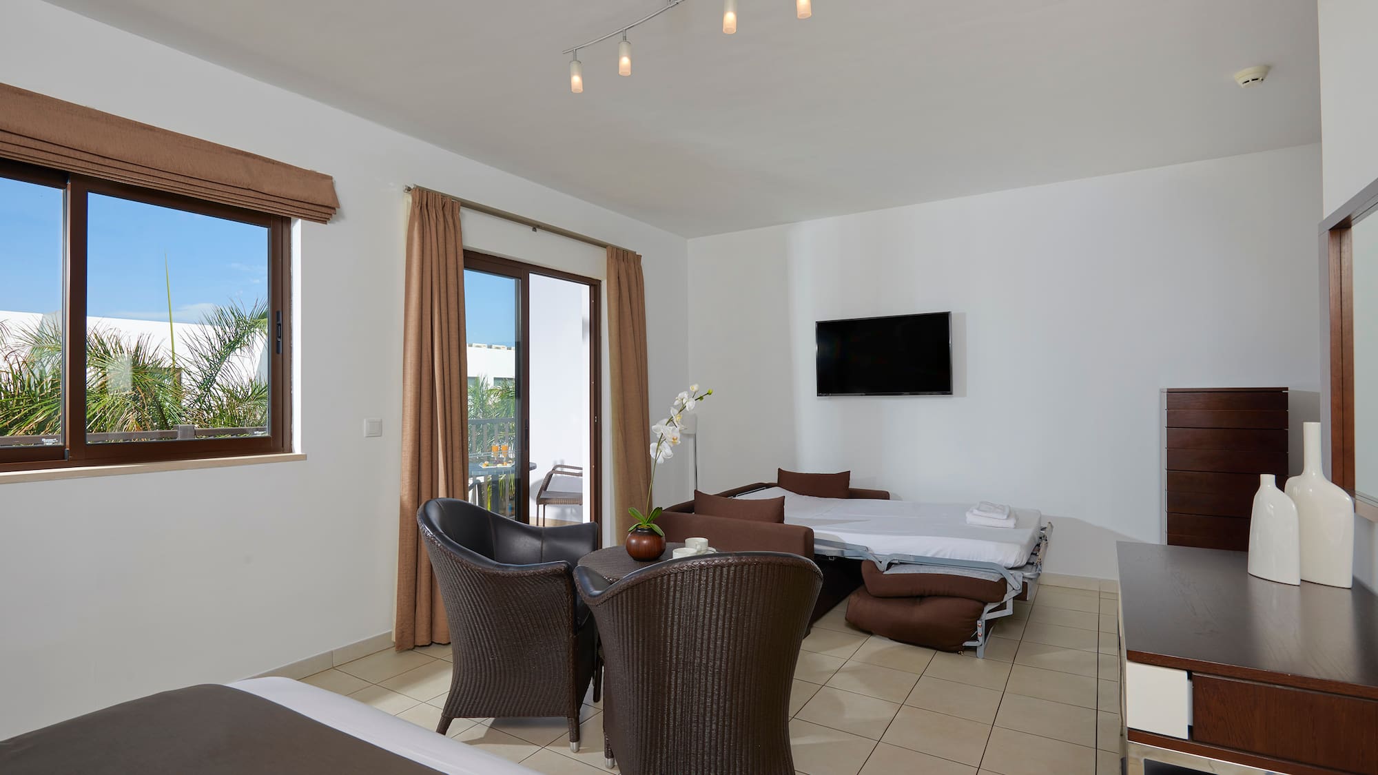 a room with a bed and chairs