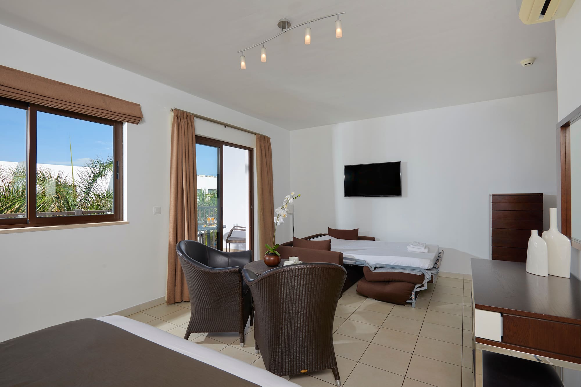 a room with a bed and chairs