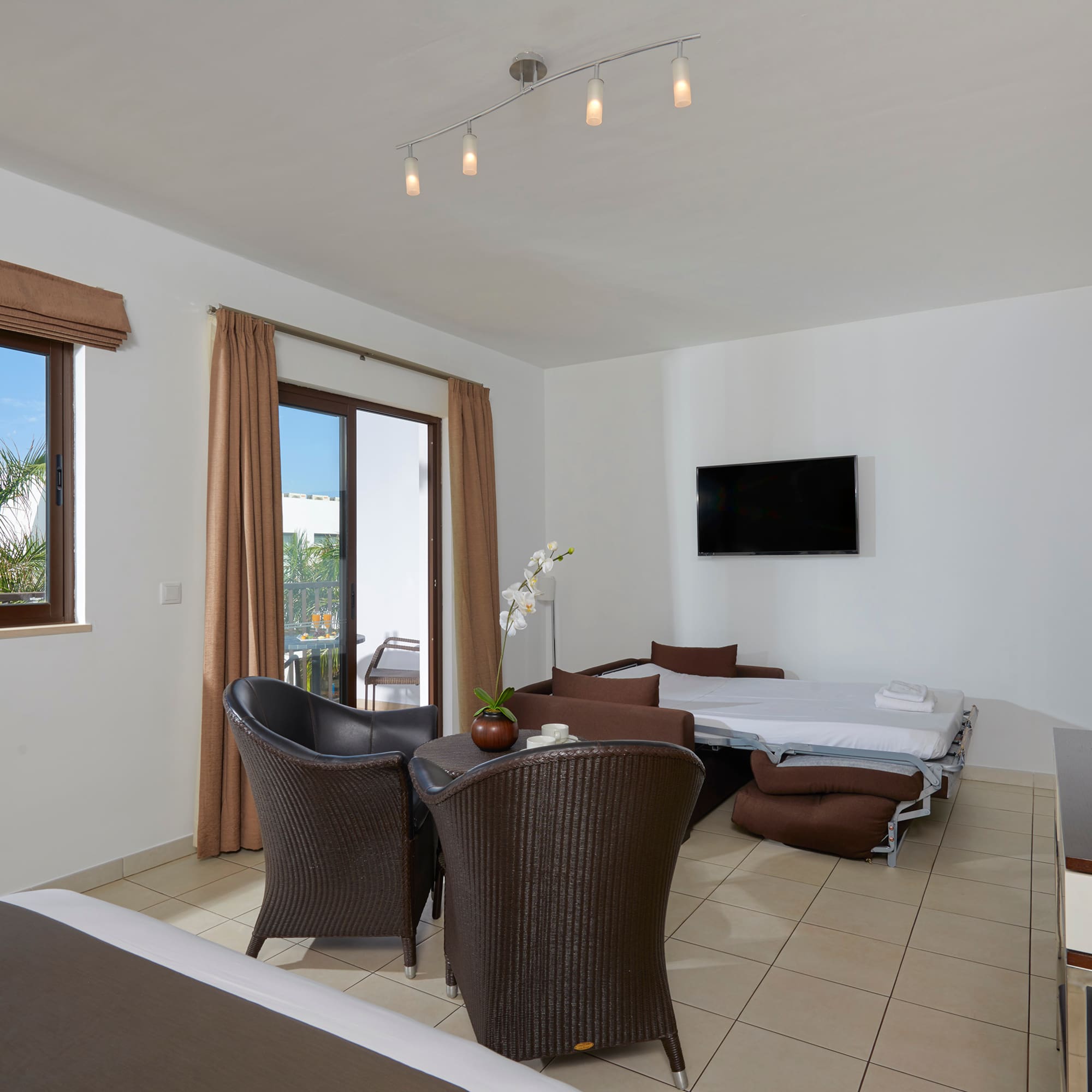 a room with a bed and chairs