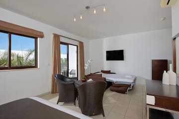 a room with a bed and chairs