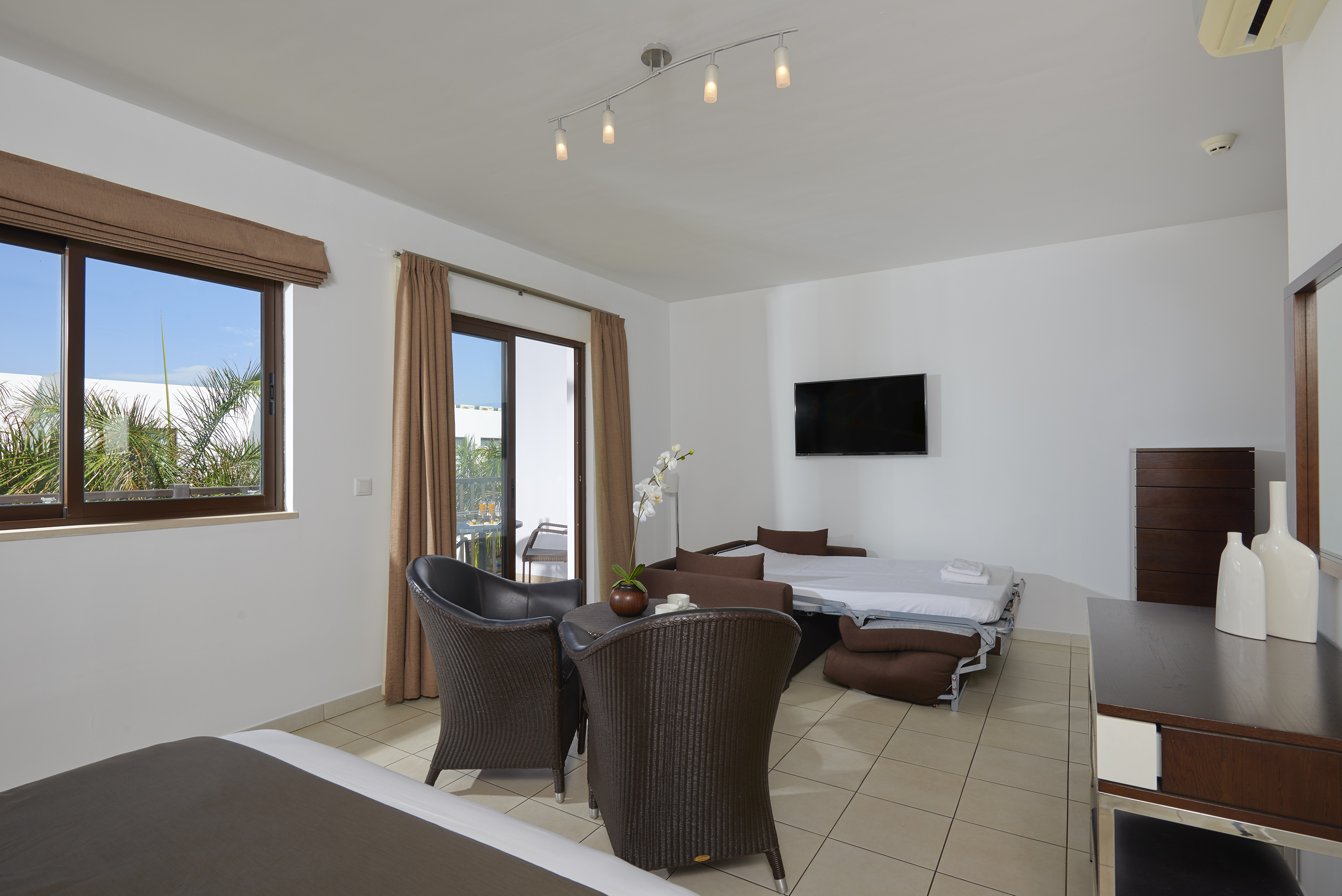 a room with a bed and chairs