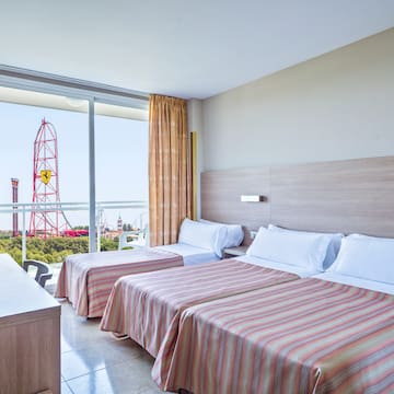 a room with two beds and a balcony with a ferris wheel in the background