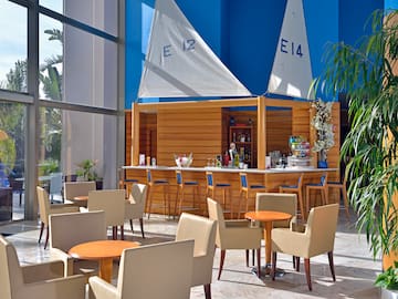 a bar with tables and chairs in a room with a blue wall