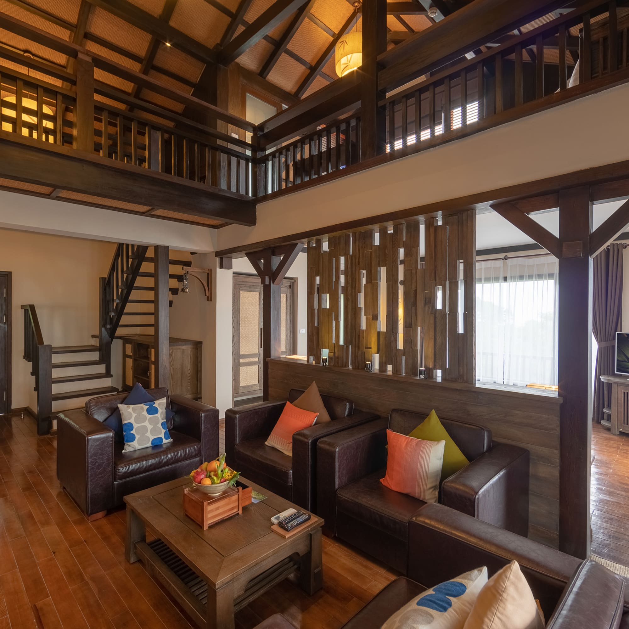 a living room with a wood floor and a wood staircase
