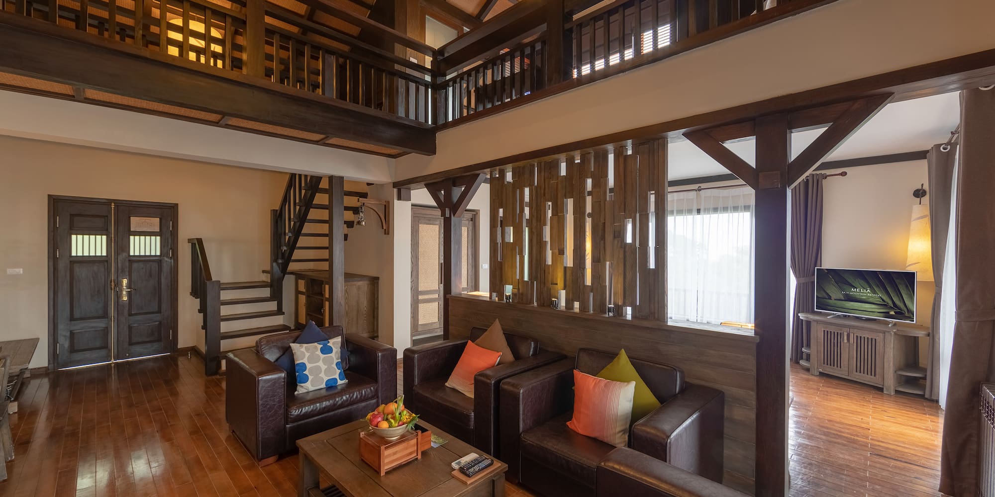 a living room with a wood floor and a wood staircase