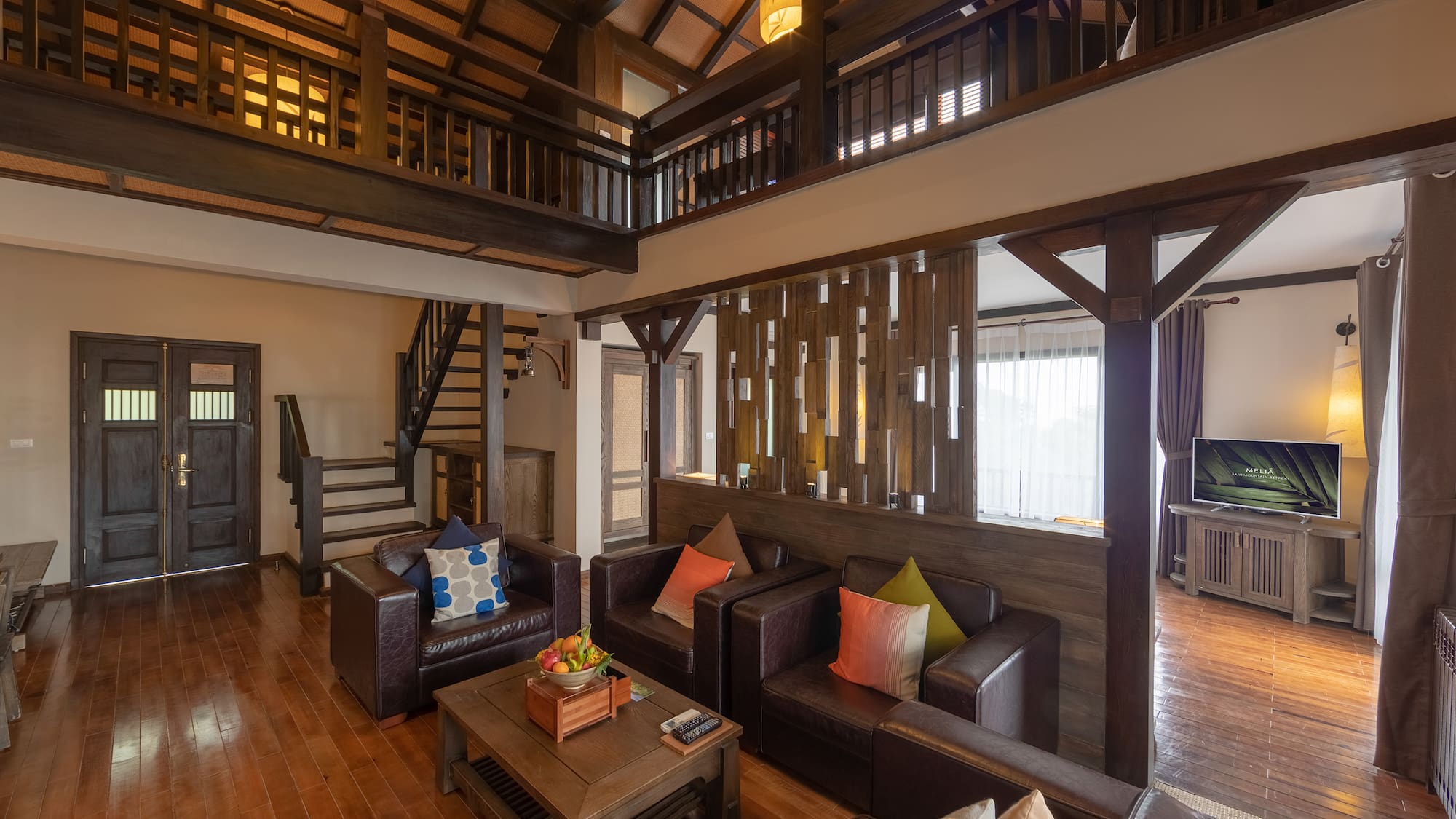 a living room with a wood floor and a wood staircase
