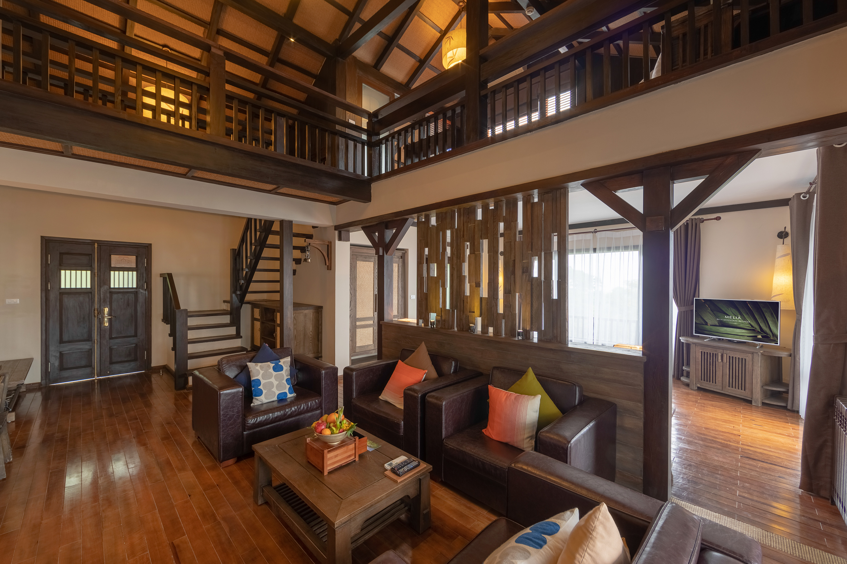 a living room with a wood floor and a wood staircase
