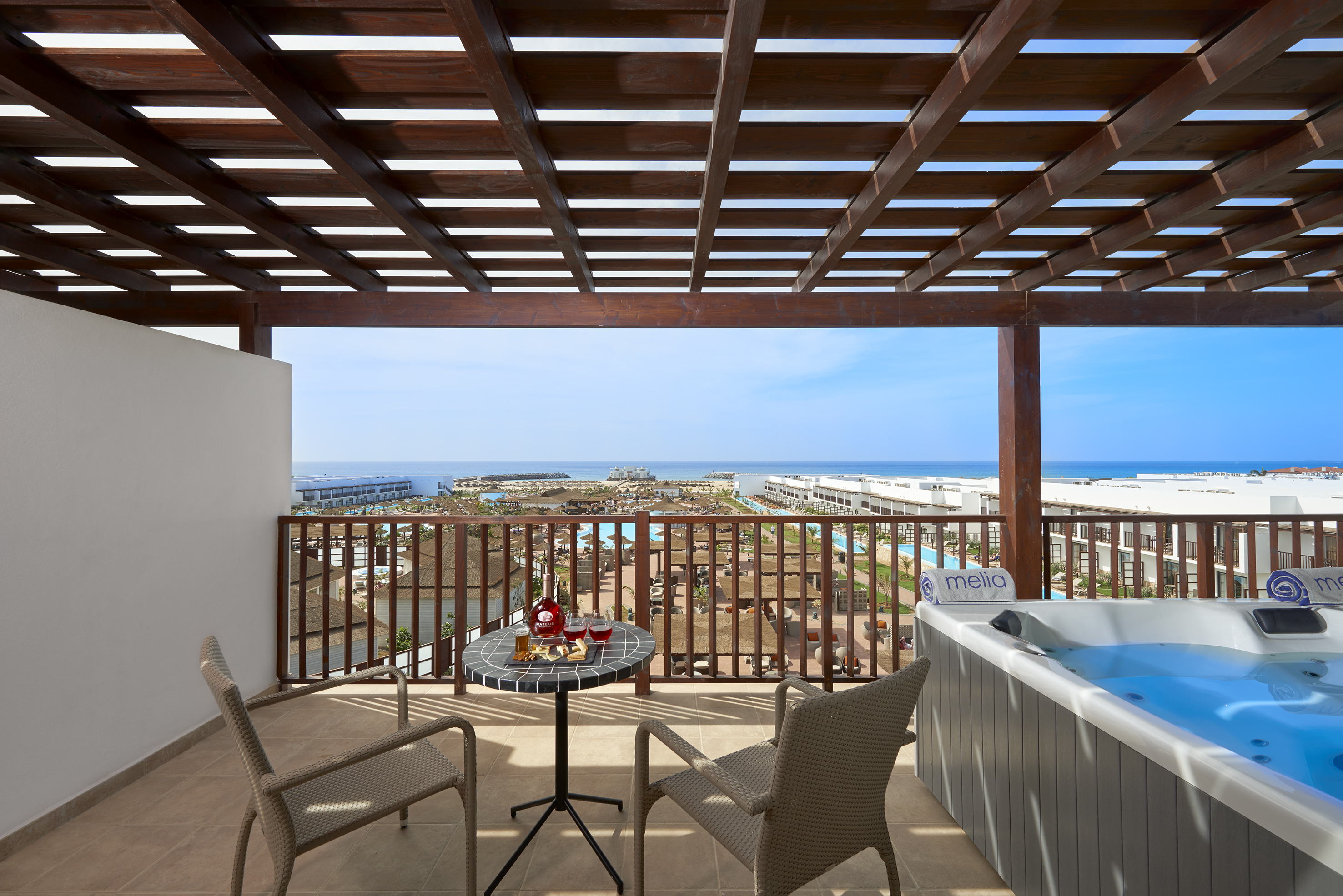 a patio with a hot tub and chairs