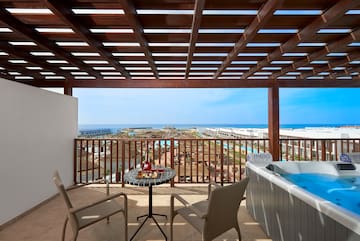 a patio with a hot tub and chairs