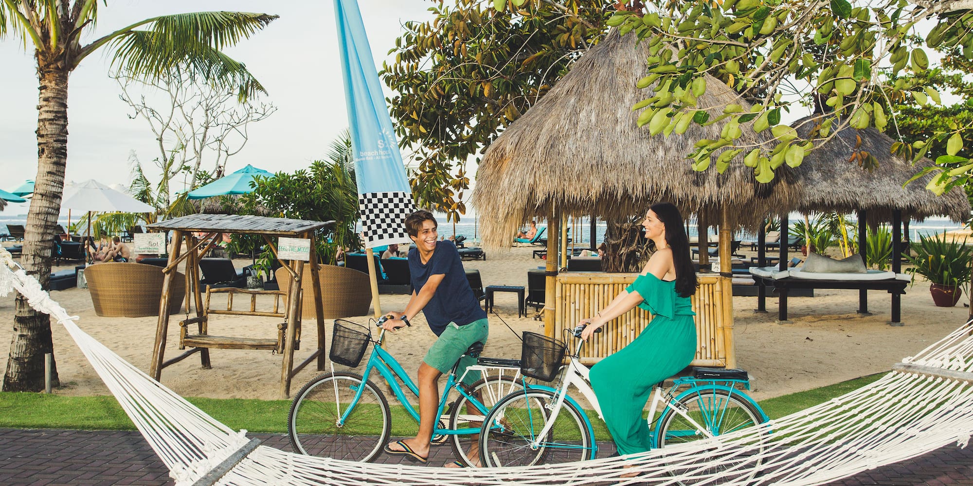 a man and woman riding bicycles in a hammock