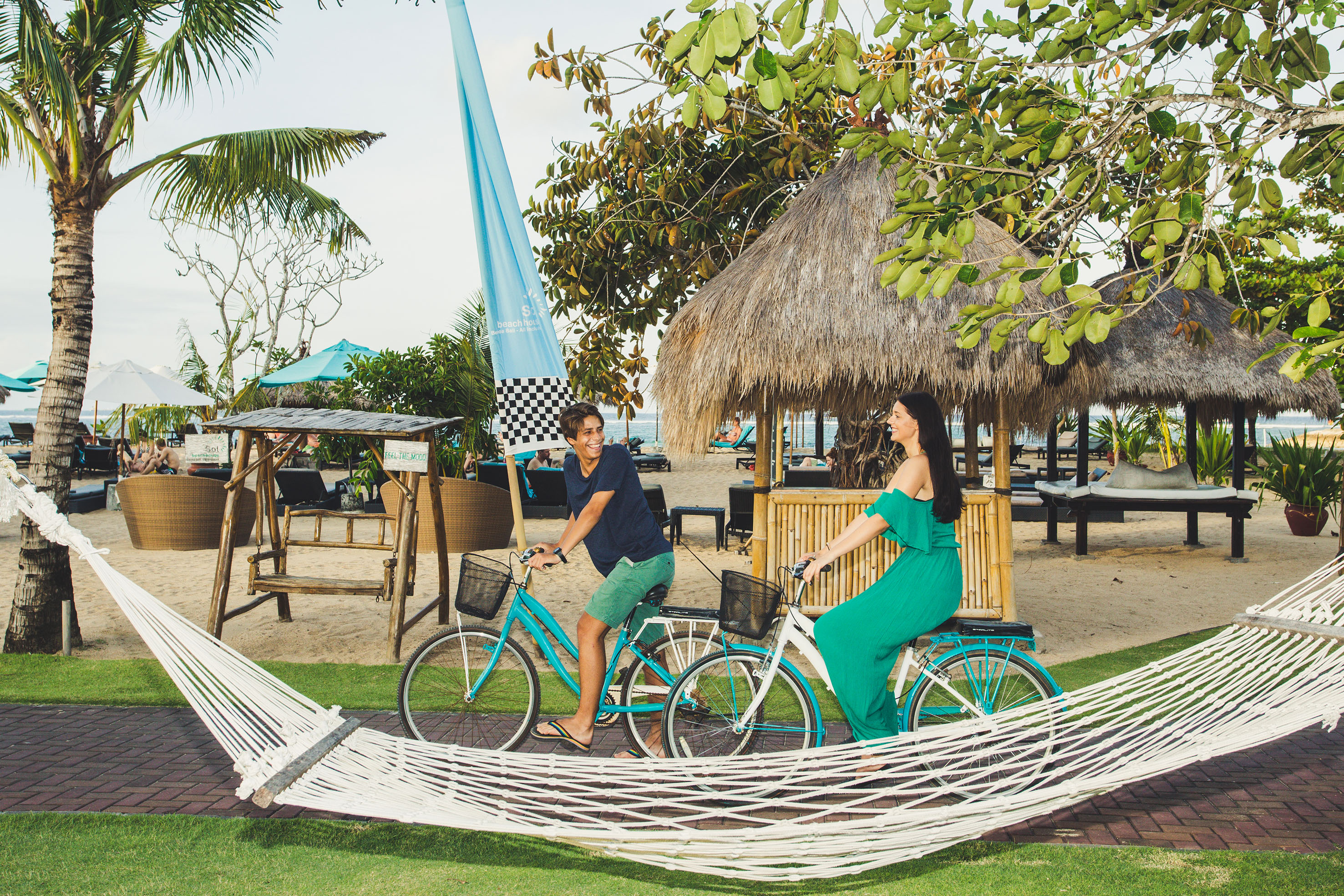 a man and woman riding bicycles in a hammock