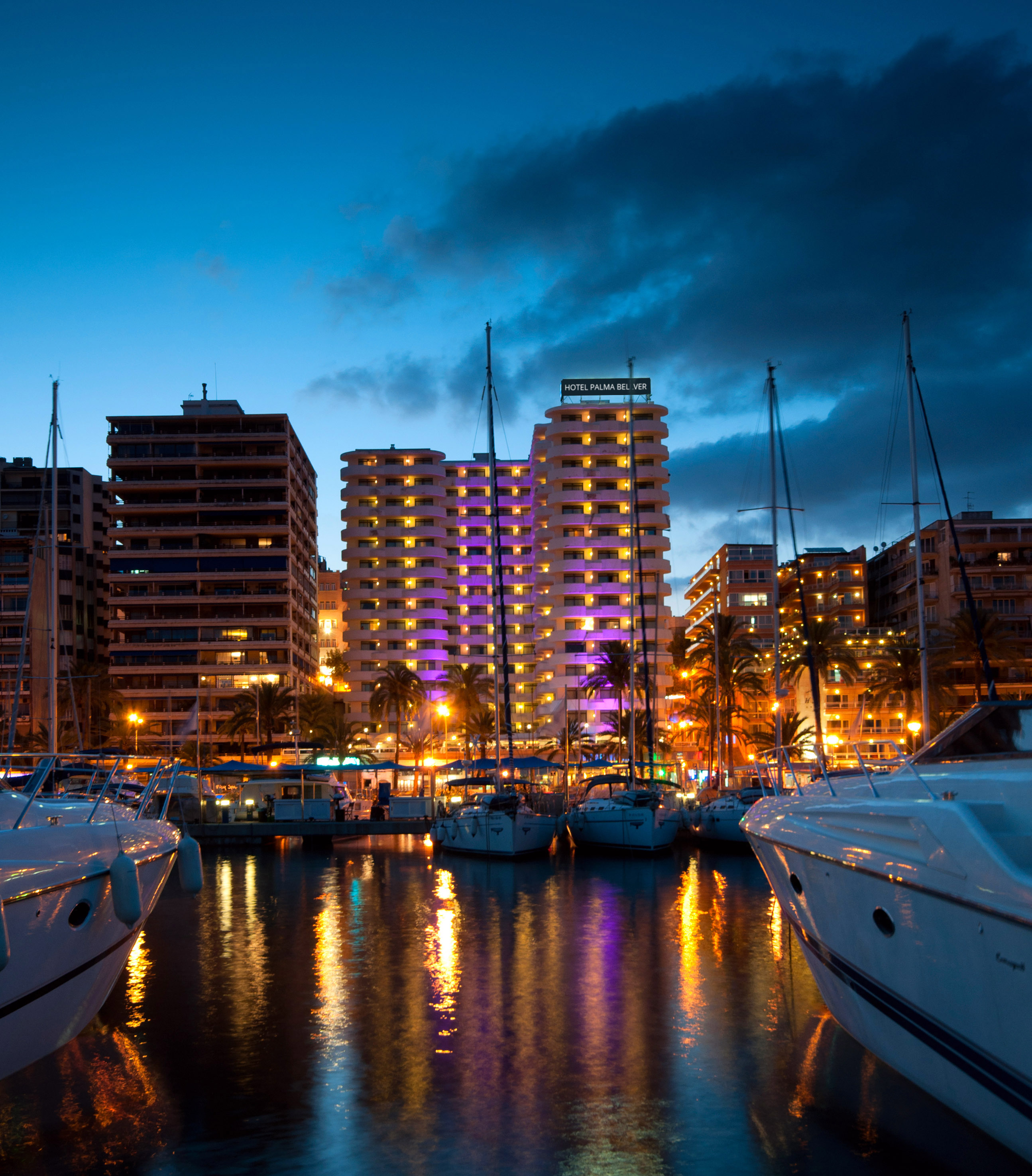 Palma de Mallorca marina at night, Hotel Palma Belver, yachts, city lights reflecting.