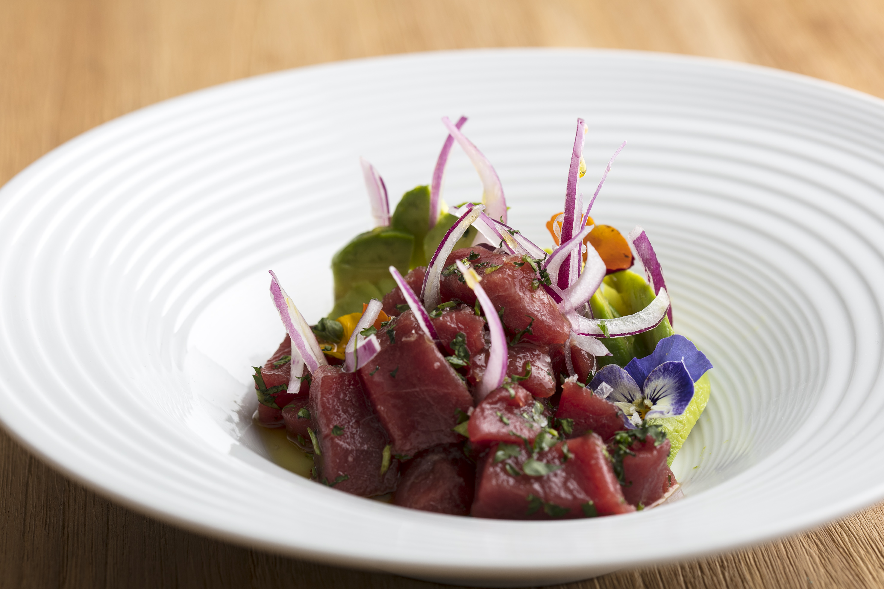 a plate of raw meat with vegetables