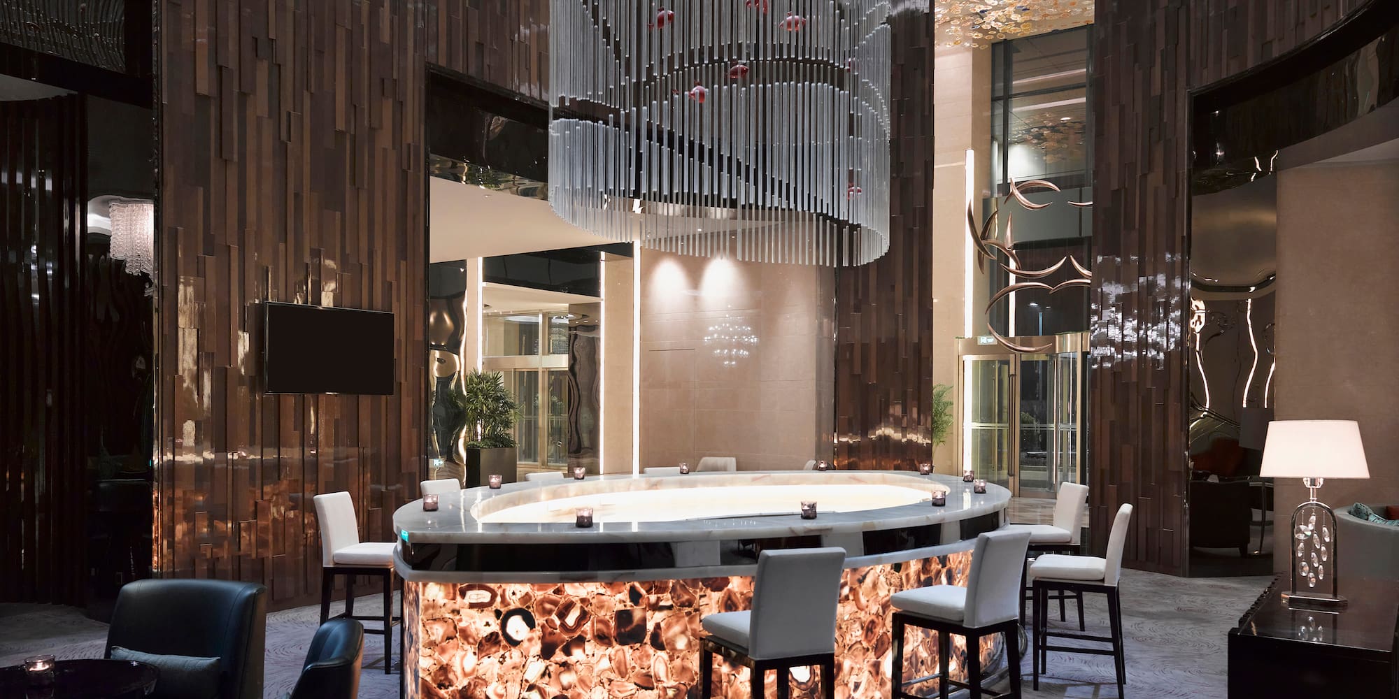 a bar with chairs and a chandelier