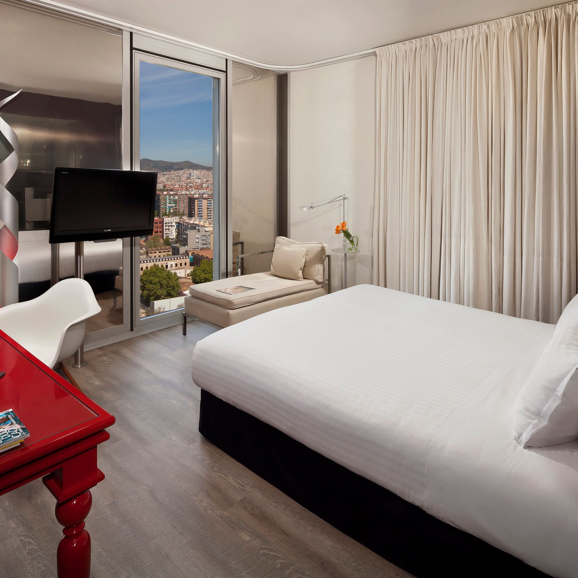 a bedroom with a red desk and a bed