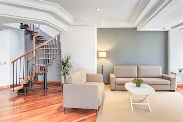 a living room with a staircase and couches