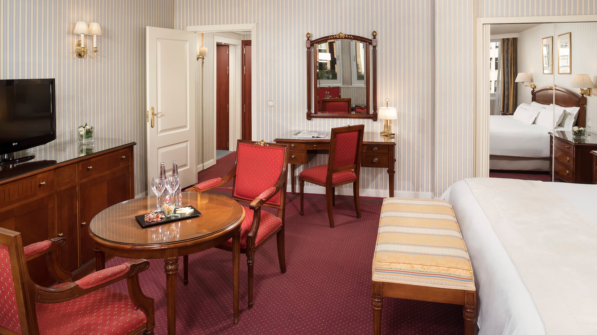 a room with a bed and chairs