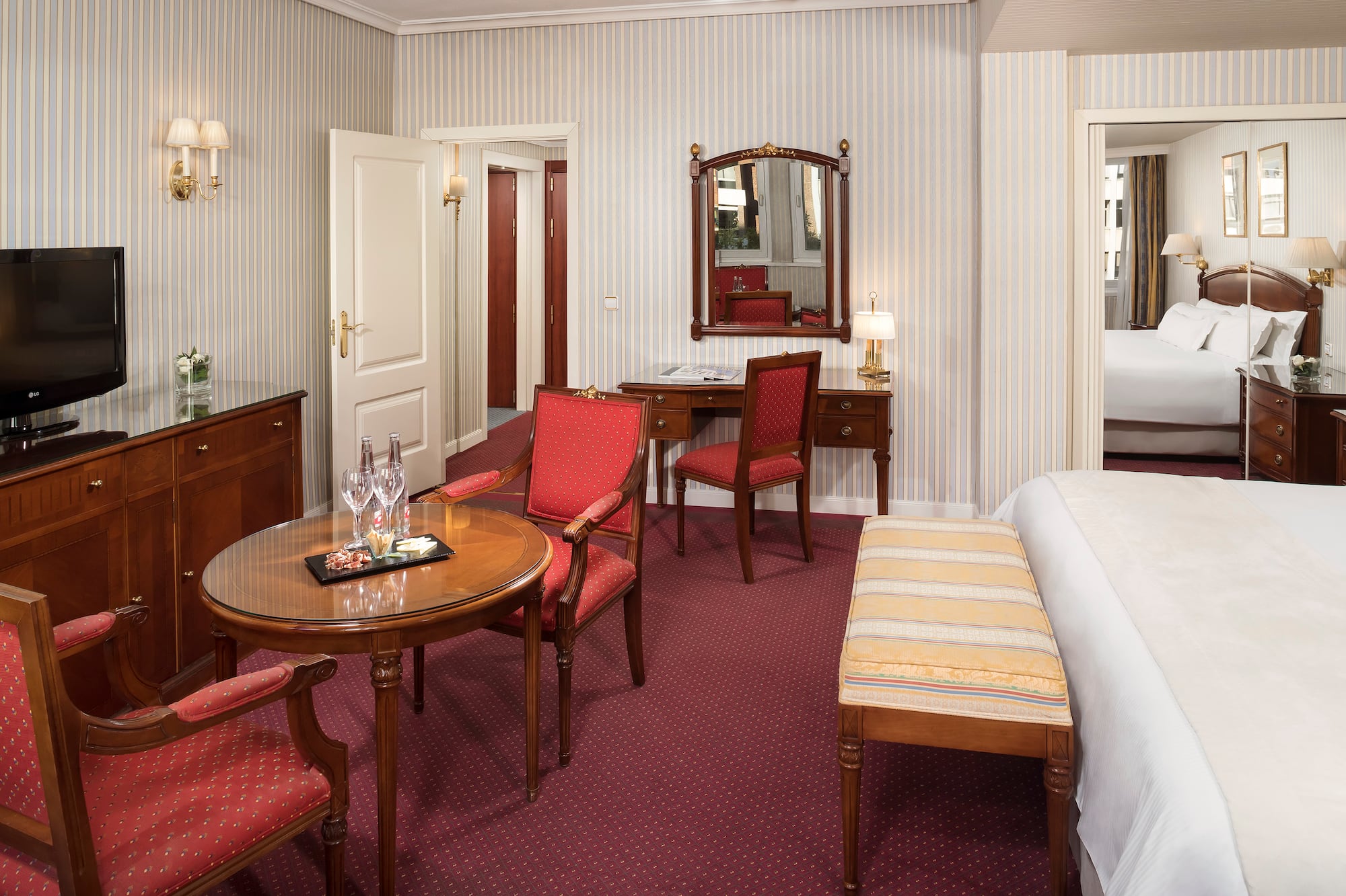 a room with a bed and chairs