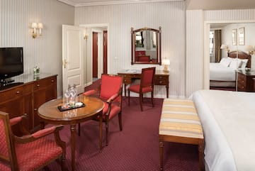 a room with a bed and chairs