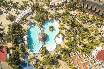 an aerial view of a resort with a pool and palm trees