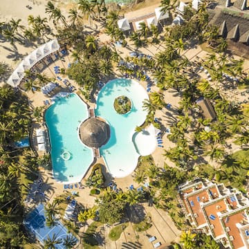 an aerial view of a resort with a pool and palm trees