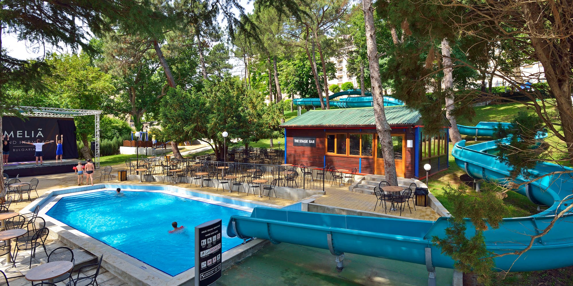 a pool with chairs and tables in a park