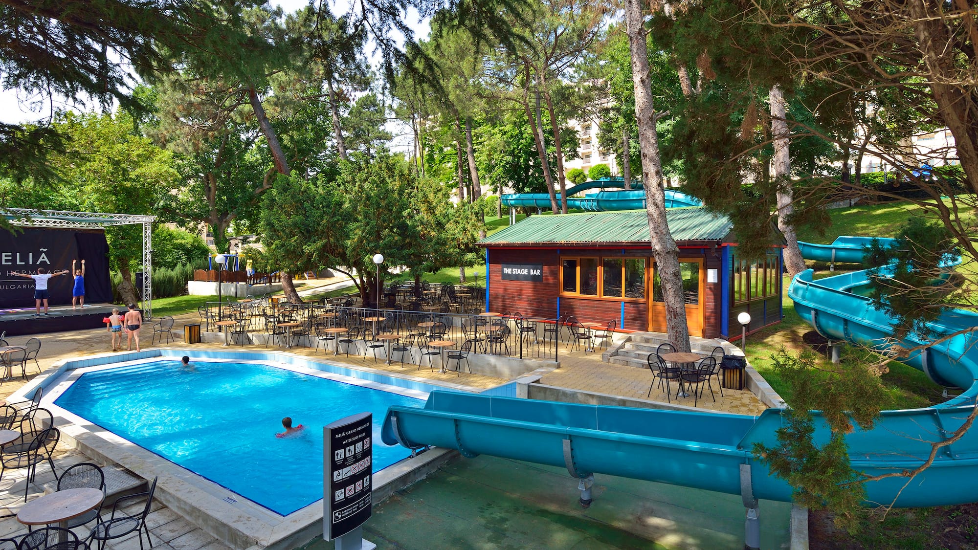 a pool with chairs and tables in a park