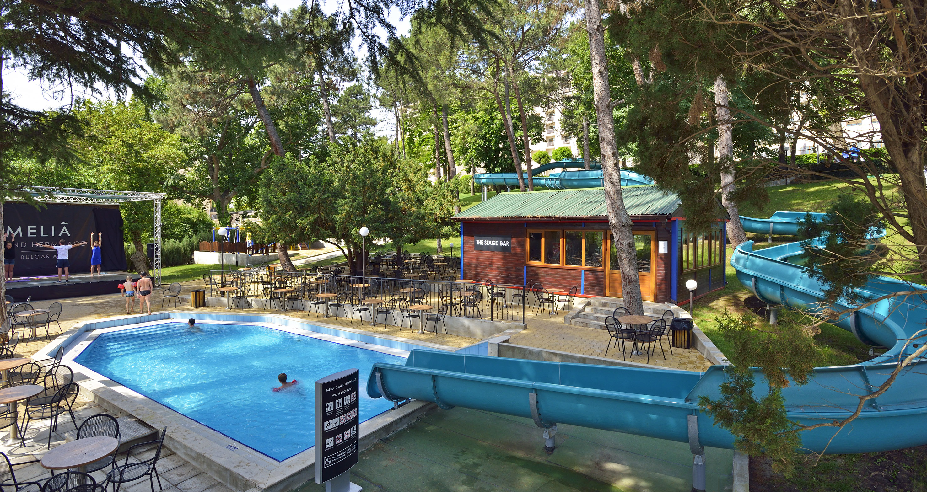 a pool with chairs and tables in a park