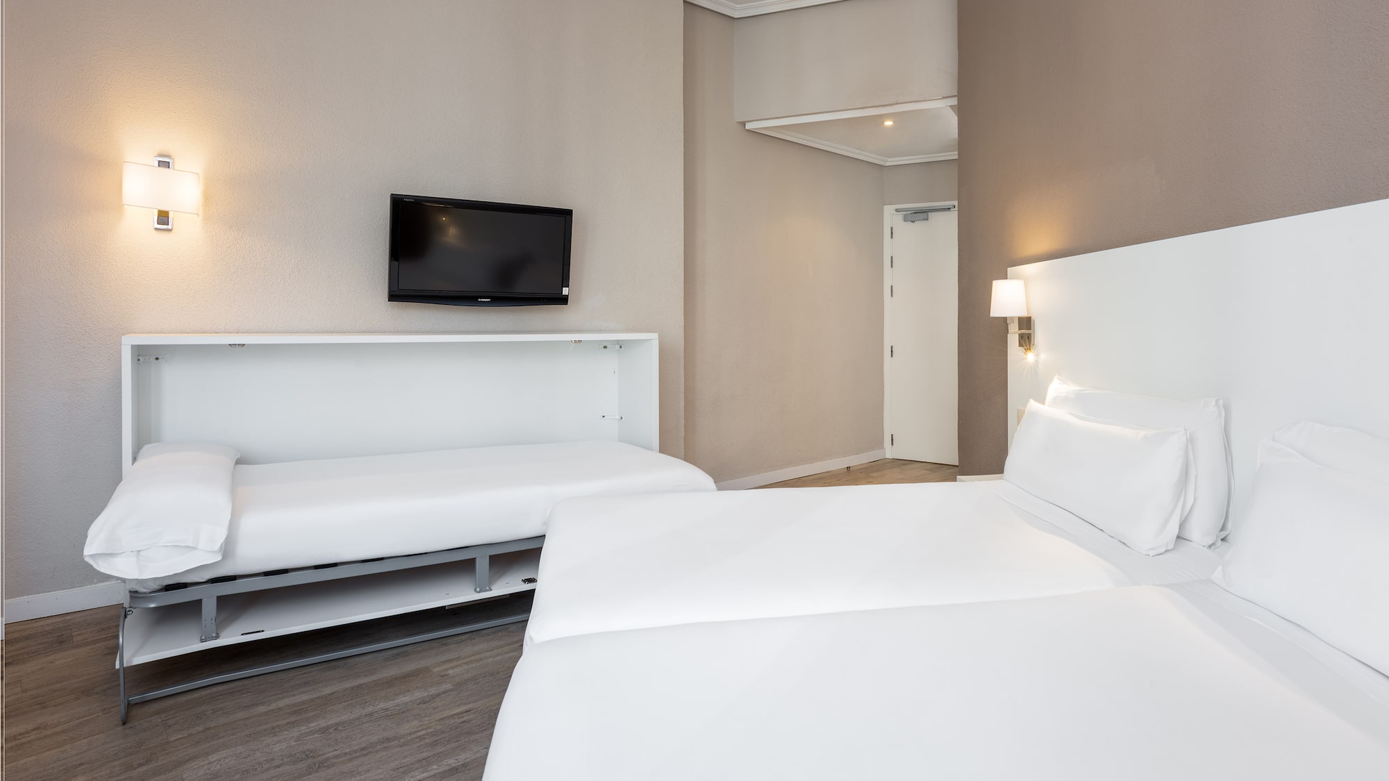 a room with two beds and a tv