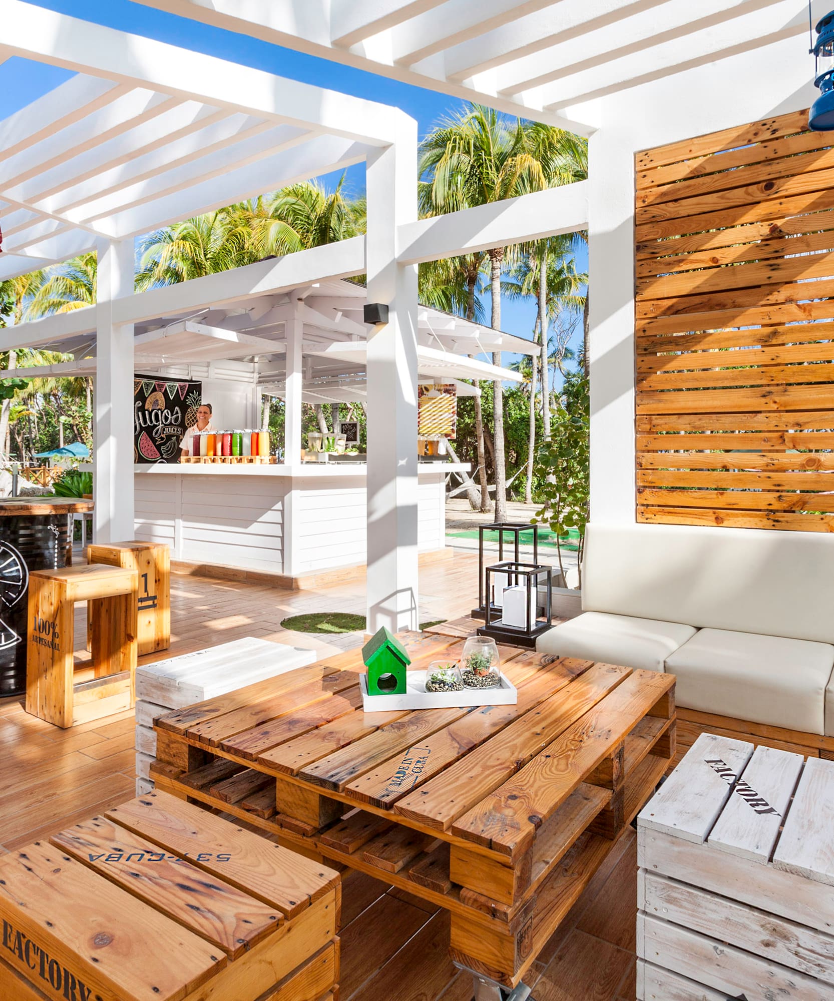 a white patio with wooden tables and chairs