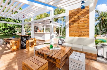 a white patio with wooden tables and chairs