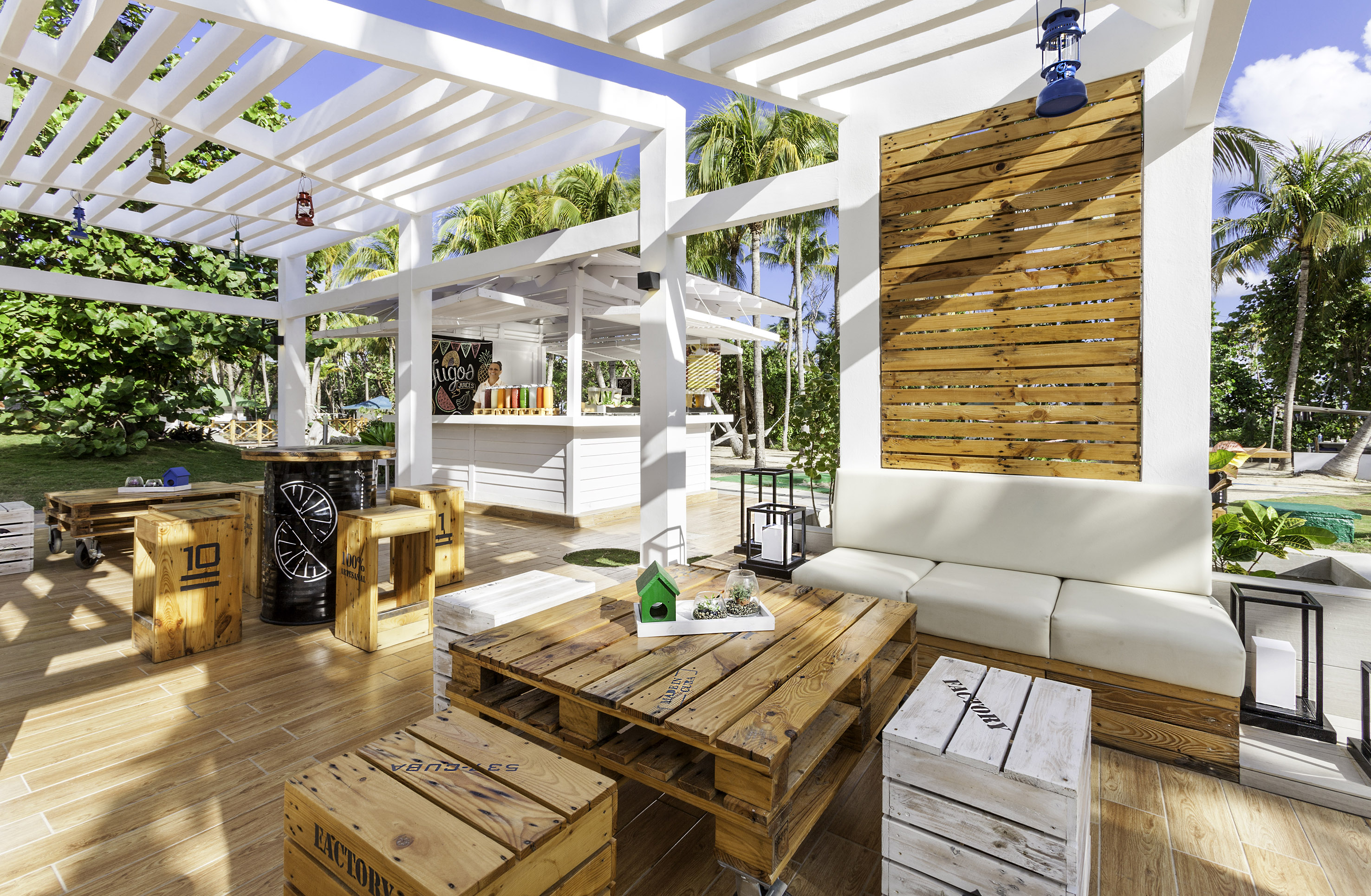 a white patio with wooden tables and chairs