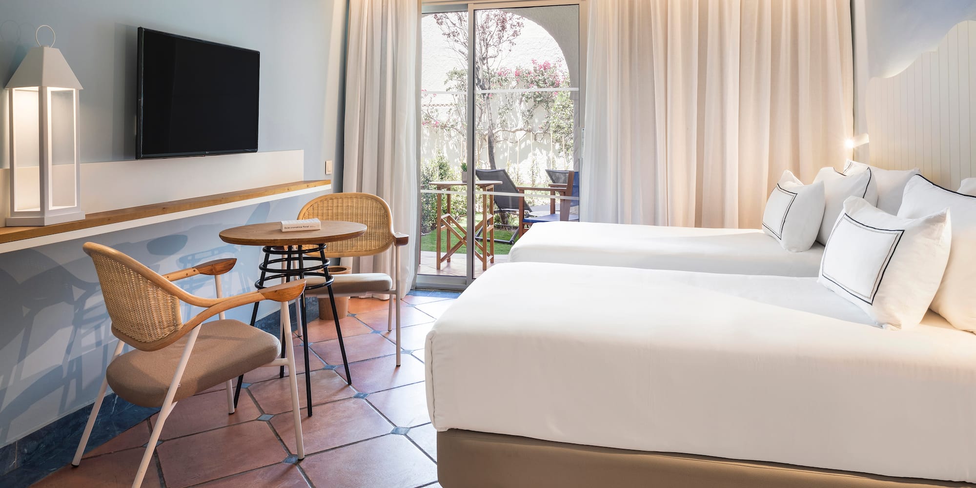 a room with two beds and a table and chairs