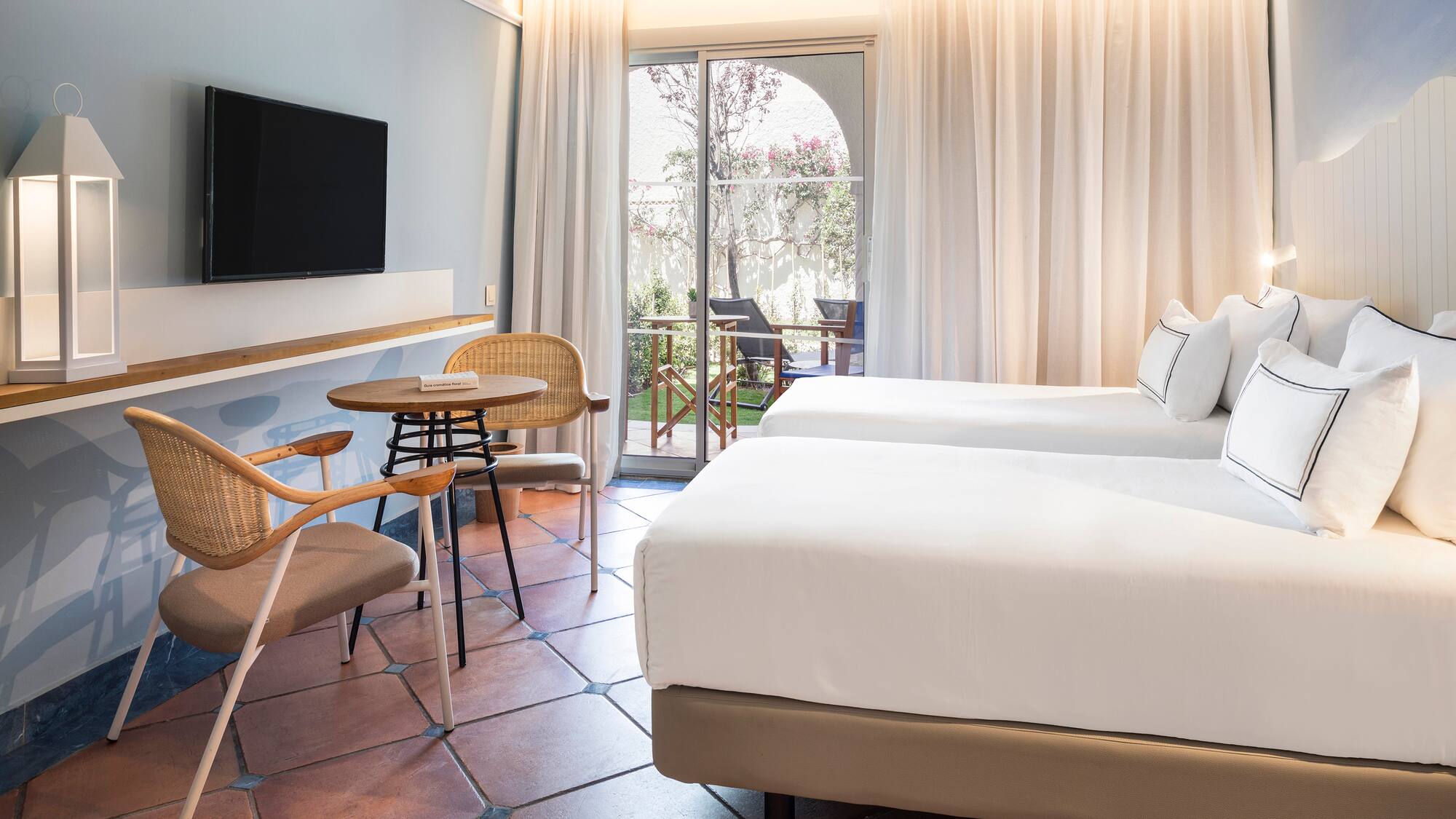 a room with two beds and a table and chairs