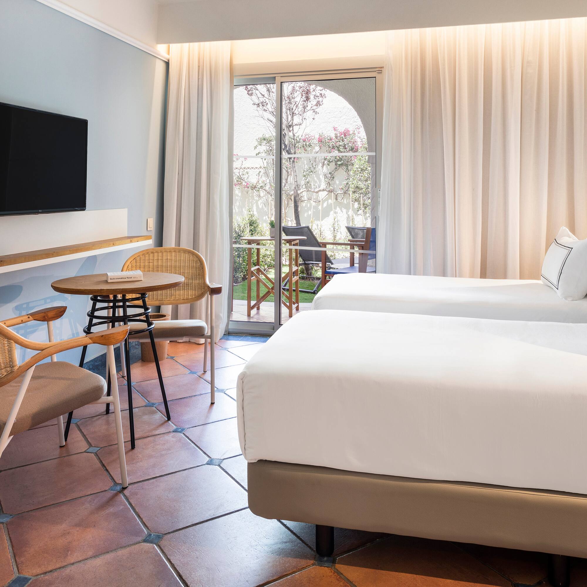 a room with two beds and a table and chairs